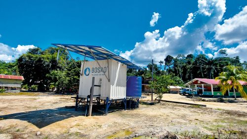 Water treatment system in a container with solar panels on the roof in a village in South America