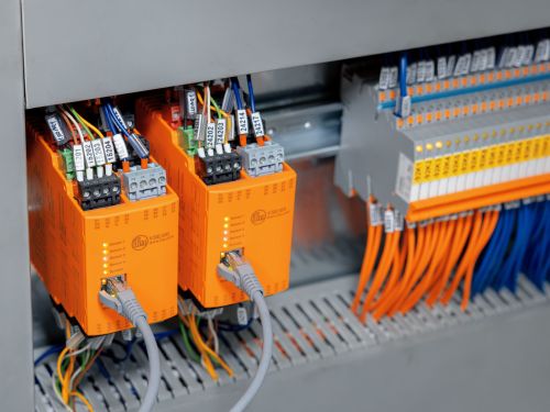 Two evaluation units mounted on a DIN rail inside a control cabinet.