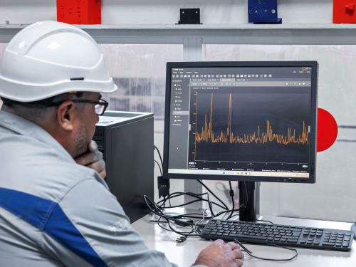 An employee at a hydroelectric power station analyses vibration data on a PC