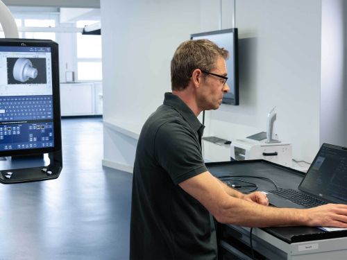 Una persona frente a un ordenador portátil maneja el software de parametrización moneo configure free de ifm