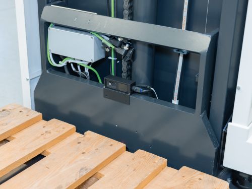 A compact camera mounted above the pallet clamp on a forklift.