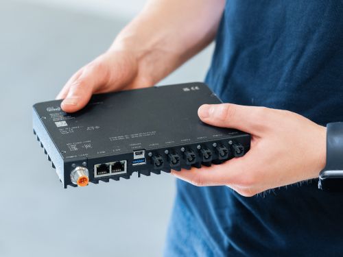 A person is holding a video processing unit.