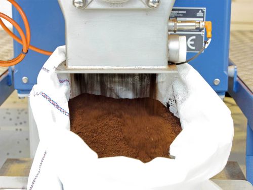 Down at the mill, the ground coffee is put into a sack.