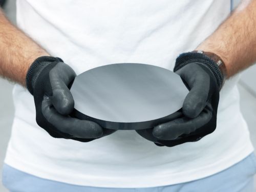 Person holding a silicon carbide crystal in their hands.