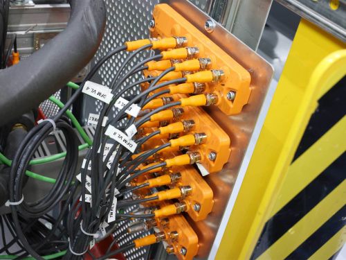 Vier übereinander montierte IO-Link-Module. Von jedem Port gehen Anschlussleitungen ab