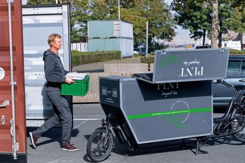 Hans Snjder from PLNT loads goods into a cargo bike.
