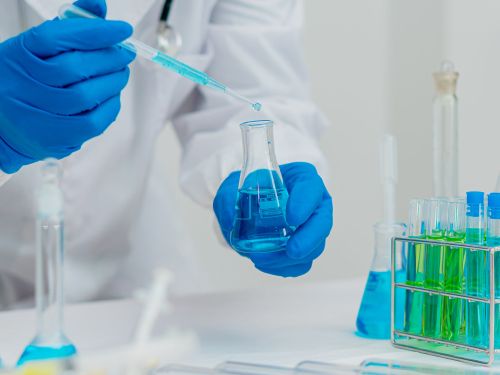 Un scientifique travaille en laboratoire avec des tubes à essai de liquide in vitro pour les chercheurs dans le domaine de la santé et de la technologie médicale