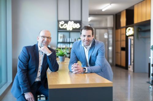 Foto von den FOX-Architekten Björn Knabe (l.) und Dr. Alexander Hoffmann (r.), die gemeinsam an einem Tisch stehen.