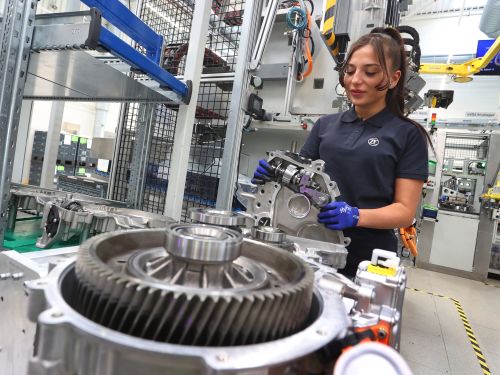 Woman mounts differential and intermediate shaft at the ZF production location in Schweinfurt.