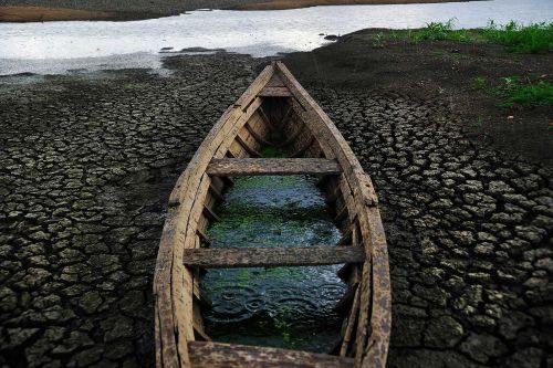 Old canoe lying on the ground of a dried-up river.