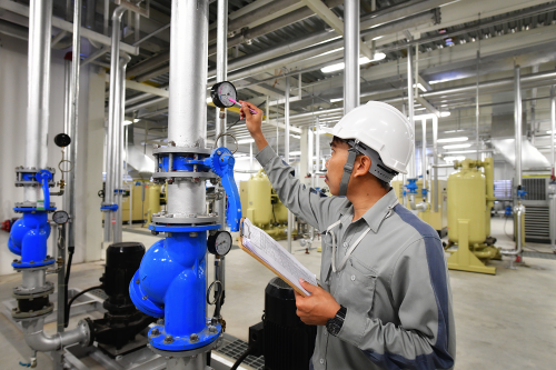 Person looking a a pressure gauge on a compressed air pipe